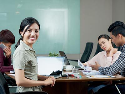 Beautiful Vietnamese business lady having meeting with colleagues